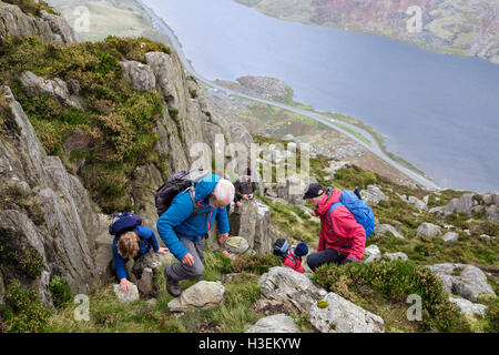 Hikers scrambling up Mount Tryfan north ridge above Llyn Ogwen in mountains of Snowdonia National Park (Eryri). Ogwen, Conwy, Wales, UK Stock Photo