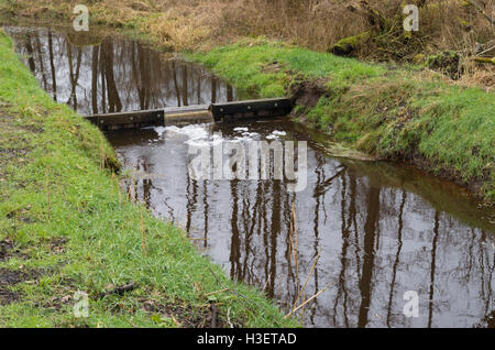 small ditch with a weir in winter time Stock Photo