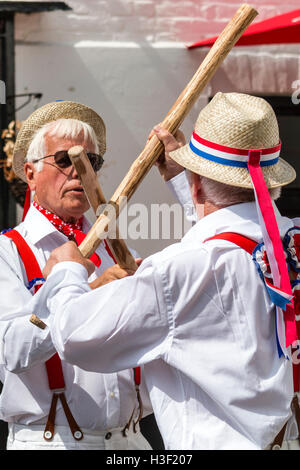 Broadstairs Folk Week. Traditional English Folk dancers, Hartley Morris side dancing and bashing poles together, Cotswold Style. Close up. Stock Photo