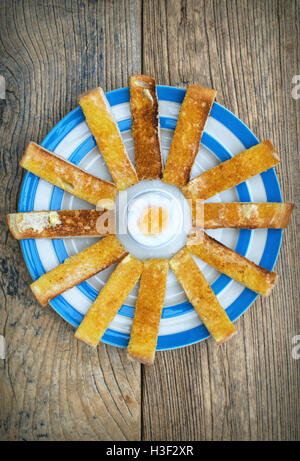 Soft boiled egg and toast soldiers on a plate from above Stock Photo