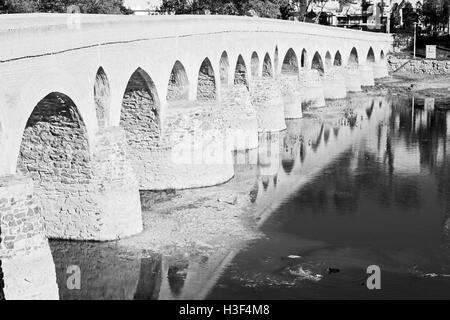 blu in iran  the old bridge and the river antique construction near nature Stock Photo