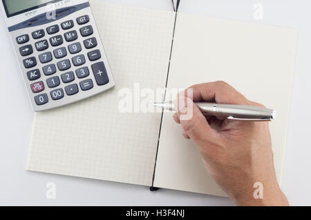 Man hand with pen writing on notepad, on white background. Stock Photo
