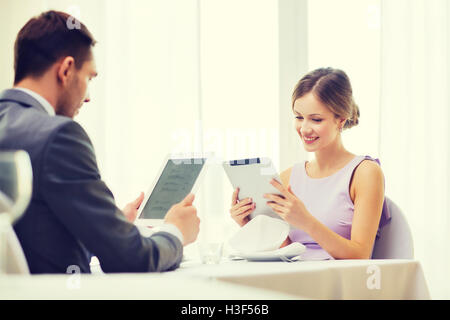 couple with menus on tablet pc at restaurant Stock Photo