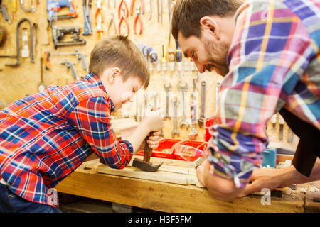 father and son with hammer working at workshop Stock Photo