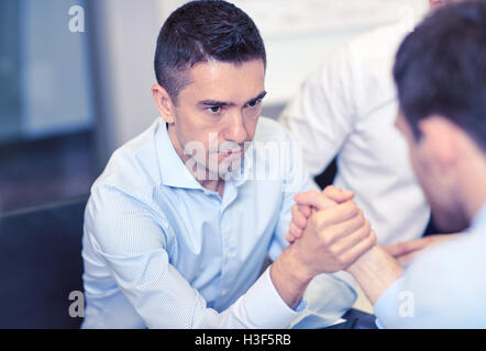 businessmen arm wrestling in office Stock Photo