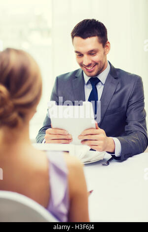 smiling man looking at menu on tablet pc computer Stock Photo