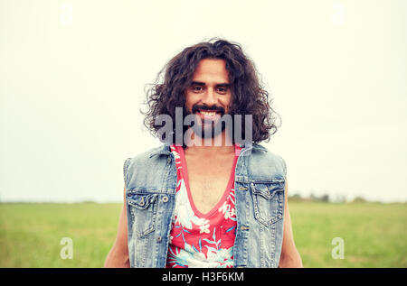 smiling young hippie man on green field Stock Photo