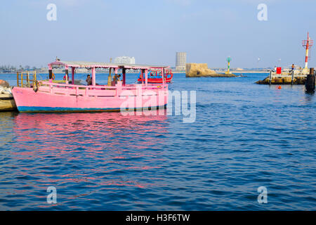 ACRE, ISRAEL - AUGUST 03, 2016: Scene of a boat in the fishing harbor, the tower of the flies, locals and tourists, in the old c Stock Photo