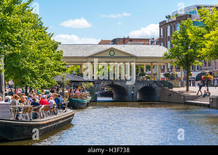 People on outdoor terraces of cafes and Korenbeursbrug bridge over New Rhine canal in Leiden, South Holland, Netherlands Stock Photo