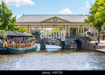 People on outdoor terrace of cafe and Korenbeursbrug bridge over New Rhine canal in Leiden, South Holland, Netherlands Stock Photo