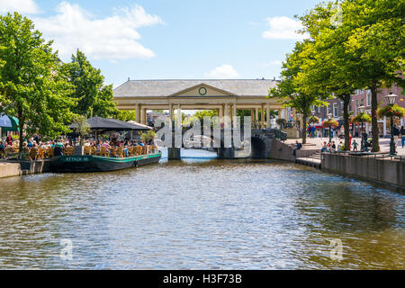 People on outdoor terrace of cafe and Korenbeursbrug bridge over New Rhine canal in Leiden, South Holland, Netherlands Stock Photo