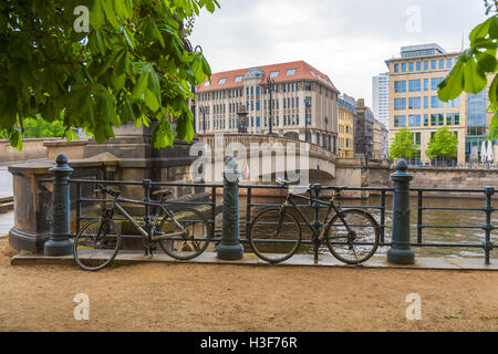 The bridge over the river Spree and a few bicycles chained to the railings of the promenade, Berlin, Germany Stock Photo