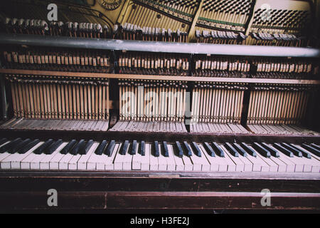 Old broken disused piano with damaged keys Vintage Retro Filter. Stock Photo