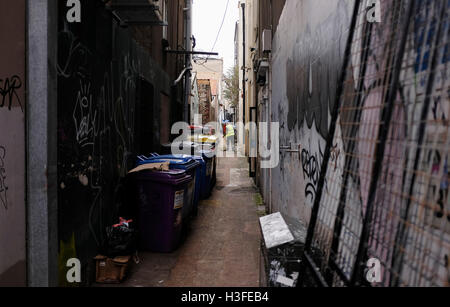 Brighton and Hove Council street cleaner worker clearing rubbish in alleyway in city centre UK Stock Photo
