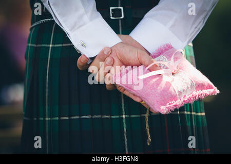 best man wearing kilt, holding wedding rings Stock Photo