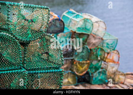 Stacked lobster creels / traps on quay in the Plockton Harbour, Scottish Highlands, Scotland, UK Stock Photo