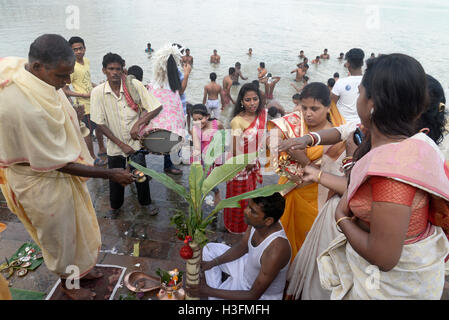 Kolkata, India. 08th Oct, 2016. Hindu priests perform prayers in front of a banana tree trunk as part of a ritual on the banks of the Ganges river during Durga Puja festival in Kolkata. Four days long Durga Puja festival started by performing Naba Patrika Snana or rituals with a banana plant as part of Durga Puja festival on the banks of River Ganaga. Credit:  Saikat Paul/Pacific Press/Alamy Live News Stock Photo