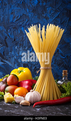 Concept of Italian food. Pasta, tomato, olive oil, pepper, parsley and cheese. Selective focus. Stock Photo