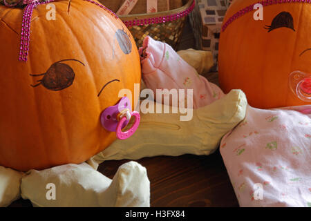 Two pumpkins dressed up as princess babies with pacifiers. Stock Photo