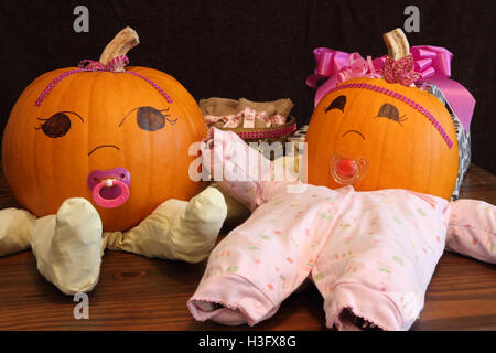 Two pumpkins dressed up as princess babies with pacifiers. Stock Photo