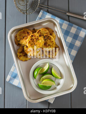 Sweetcorn fritters with lime wedges Stock Photo