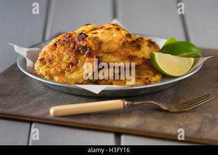 Sweetcorn fritters with lime wedges Stock Photo