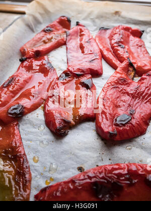 Shiny red roasted peppers in baking tray Stock Photo