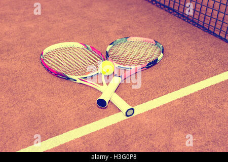 Two tennis rackets with a tennis ball lying near net on a green grass court  outdoors in summer or spring Stock Photo - Alamy