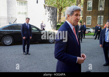 U.S. Ambassador to the United Kingdom Matthew Barzun looks on U.S. Secretary of State John Kerry speaks to reporters outside No. 10 Downing Street in London, U.K., on July 19, 2016, after becoming the first U.S. government official to hold a bilateral meeting with newly installed sits with British Prime Minister Theresa May. Stock Photo