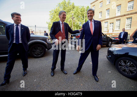 U.S. Secretary of State John Kerry, joined by U.S. Ambassador to the United Kingdom Matthew Barzun, bids farewell to his former counterpart, Philip Hammond, the ex-British Foreign Secretary and now Chancellor of the Exchequer, on July 19, 2016, after they bumped into each other outside the Downing Street leadership complex in London, U.K., as the Chancellor was leaving a meeting with newly installed British Prime Minister Theresa May and the Secretary was en route to meet with the new Foreign Secretary, Boris Johnson.