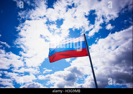 SAINT-PETERSBURG, RUSSIA - AUGUST 02, 2015: Russian flag on the background of bright sky with volumetric clouds. Patriotic Stock Photo