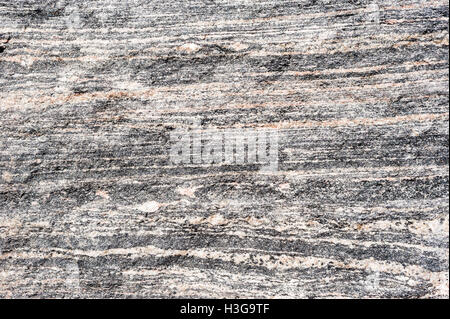 Background texture of layered light and dark metamorphic rock. Stock Photo