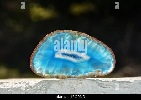 Light Blue agate slice on white walls with dark background Stock Photo