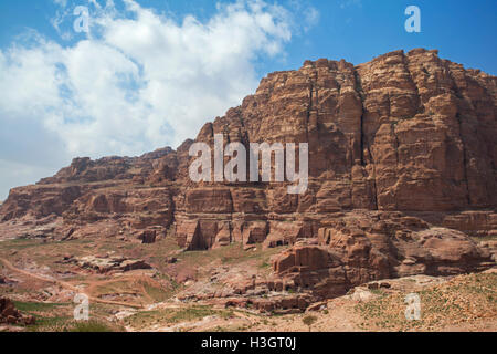 View of a rocky mountain with many ancient Nabatean tombs carved in the stone, inside the archaeological site of Petra, Jordan. Stock Photo