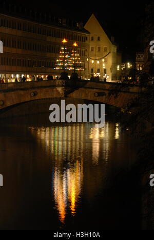 Reflections on the river Pegnitz from a pair of Christmas trees on the Museumsbrucke (Museum bridge) in Nuremberg, Germany Stock Photo