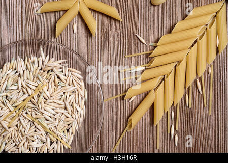 View from the top down on the pasta and grains of wheat with copy space over weathered wooden table Stock Photo