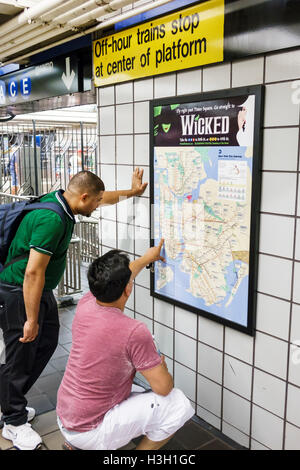 New York City,NY NYC Manhattan,Times Square,42nd Street,subway,station,MTA,turnstile,exit,Hispanic Asian adult,adults,man men male,passenger passenger Stock Photo