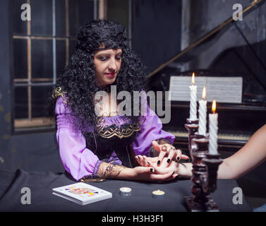 Sorceress reading somebody's hand Stock Photo