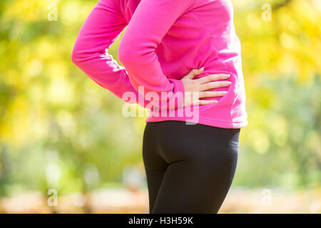 Warming up outdoors in the autumn, hands on the hips Stock Photo