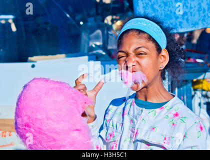 happy girl eats the hot cotton candy just prepared Stock Photo