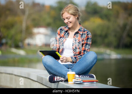 Portrait of a student sitting turkish at bridge with tablet Stock Photo