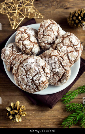 Chocolate crinkle cookies for Christmas with golden ornaments - homemade festive Christmas bakery Stock Photo