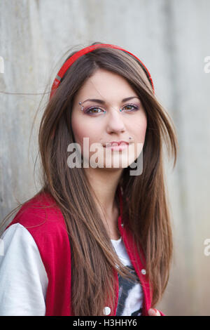 beautiful smiling teenager girl with piercing and make up listening music in headphones. Selective focus Stock Photo