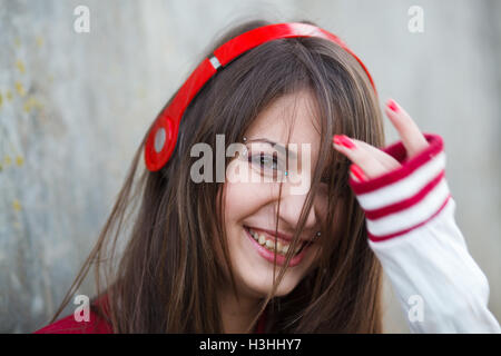 beautiful smiling teenager girl with piercing and make up listening music in headphones. Selective focus Stock Photo