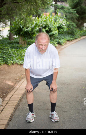 Closeup portrait, old gentleman in white shirt having difficulties with extreme heat, high temperatures, very tired, panting, ha Stock Photo