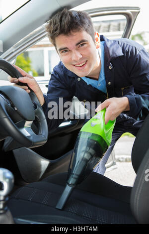 Man Hoovering Seat Of Car During Car Cleaning Stock Photo