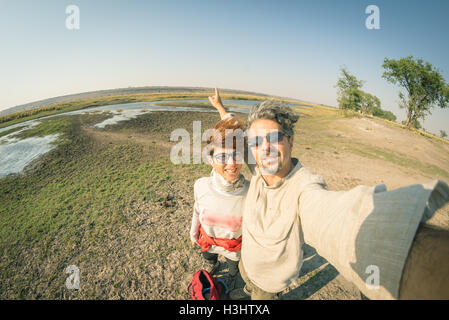 Couple taking selfie on Chobe River, Namibia Botswana border, Africa. Fisheye view from above, toned image. Chobe National Park, Stock Photo