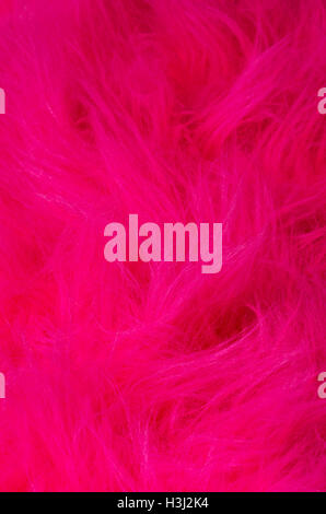 Pink plush fabric vertical. Very soft polyester textile made of synthetic fibers with long hairs. Macro close up photo. Stock Photo