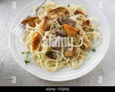 Wiild  chanterelle or girolle, Pied de Mouton Mushrooms  or hedgehog, Pied Bleu or blue foot musrooms with pasta Stock Photo