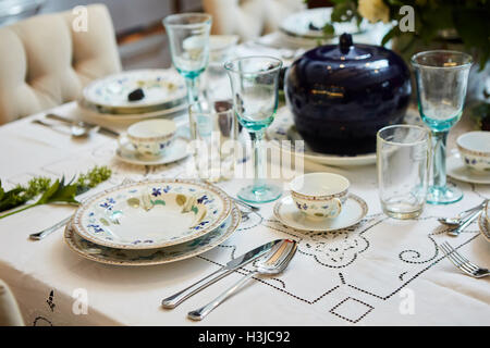 Beautifully decorated table set with flowers, candles, plates and serviettes for wedding or another event in the restaurant. Stock Photo